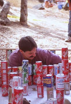 A caver carefully navigates obstacles created from soda cans, simulating an in-cave experience.